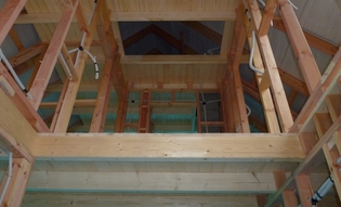 Снимок, показывающий интерьер дома в сыром виде: видны конструктивные элементы, закрытый потолок со щечными ступенями